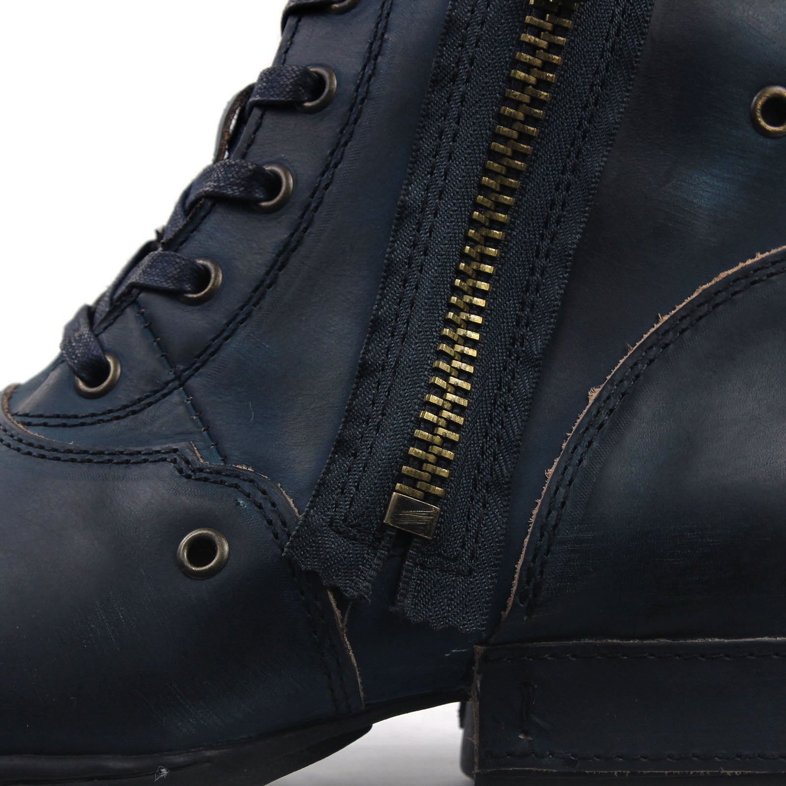 Osstone Close-up of a navy blue leather boot with a gold zipper